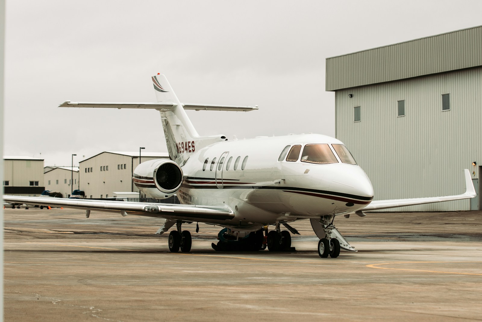 Midsize jet parked on the apron outside a hangar