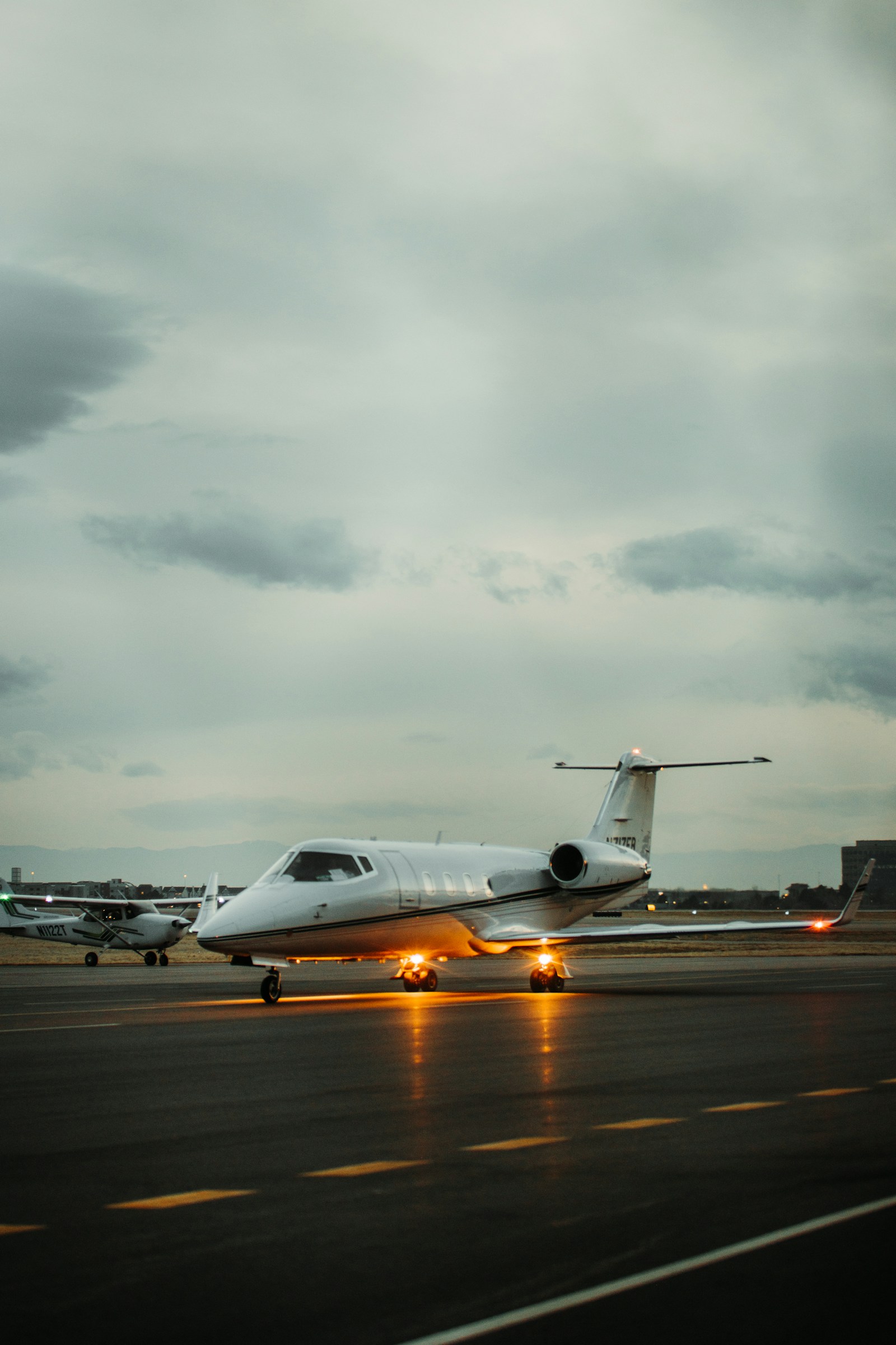 Learjet taxiing at dusk with navigation lights on